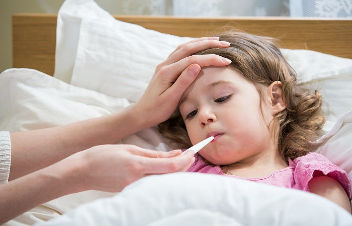 Mother giving sore throat medication to child