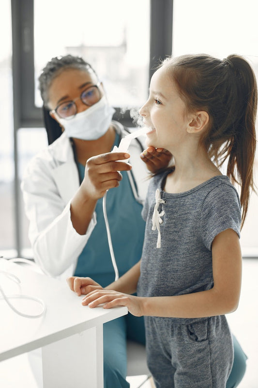 krankenschwester hilft einem asthmatisch keuchenden Mädchen mit einem Vernebler
