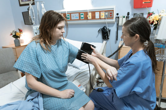 nurse taking blood pressure of a patient at hospital