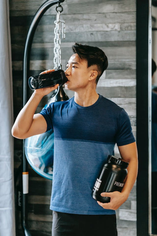 man in gym drinking whey protein