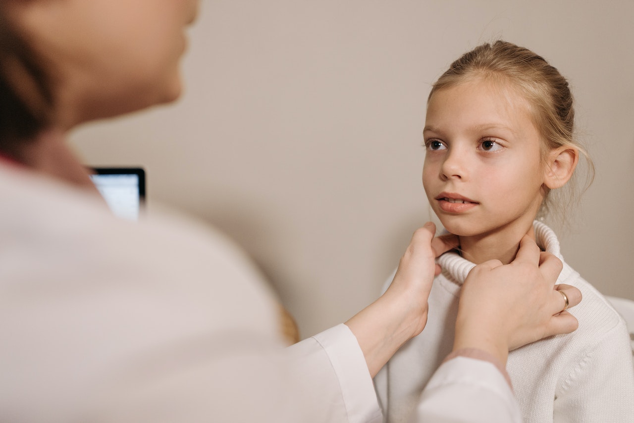 doctor checking young girl tonsils